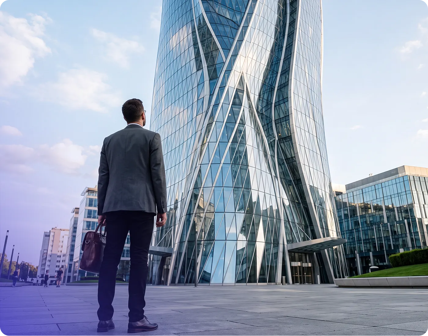 Businessman with briefcase looking up at a modern twisting glass skyscraper in a city plaza.